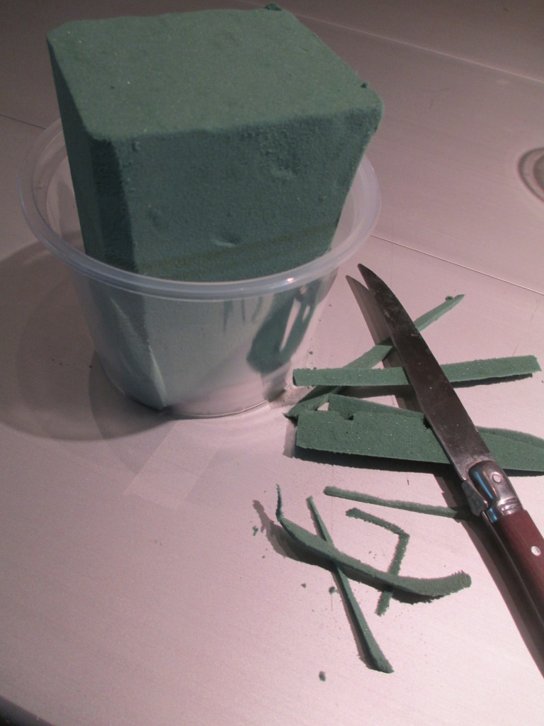 https://lolajack.jp.net/diy-project-blooming-topiary/Step # 1 ~ trim the oasis so it fits into a small plastic container, then insert in your clay pot