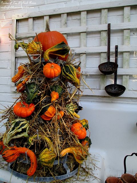 Gourd Tower ~ hay & gourds fill a metal bottle rack https://lolajack.jp.net/autumn-garden-accents-inside-and-out/